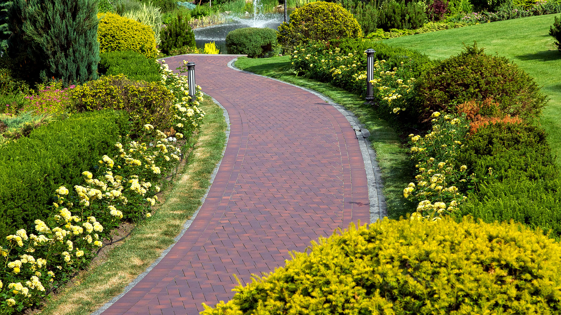 brick walking path with yellow flowers